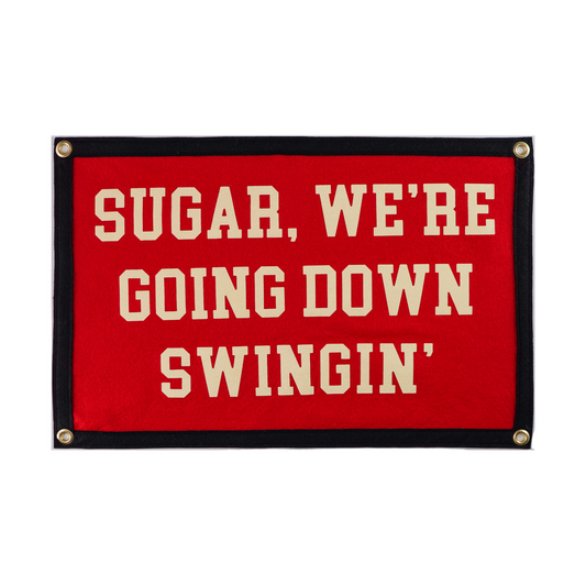 Red sign with white text 'SUGAR, WE'RE GOING DOWN SWINGIN'' and a black border
